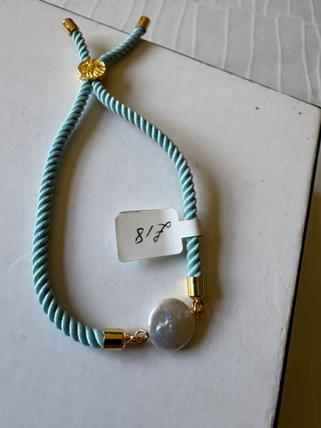 Bracelet: Pearl coin corded slider bracelets in goldtone.
